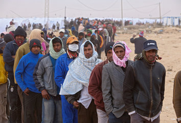 Ben Gardane  Tunesien  Fluechtlinge im Fluechtlingslager Shousha warten auf eine Essensverteilung