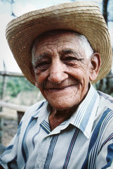 Cienfuegos  Kuba  aelterer Mann mit Strohhut laechelt freundlich