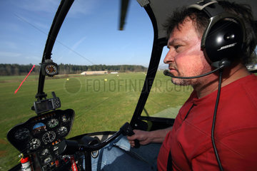 Beromuenster  Schweiz  Hubschrauberpilot waehrend eines Fluges im Cockpit