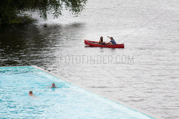Berlin  Deutschland  Besucher im Badeschiff am Spreeufer und Kanuten auf der Spree
