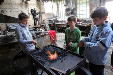 Cammin  Deutschland  Jungen erhitzen Eisenstangen im Feuer