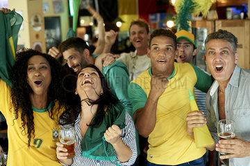 Brazilian soccer fans watching match together at pub