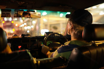 Hongkong  China  Taxifahrer faehrt durch das naechtliche Hongkong