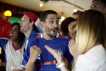 French football fans celebrating victory in bar