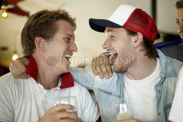 Sports enthusiasts celebrating together in bar