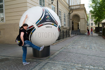 Lemberg  Ukraine  junge Frau posiert vor einem uebergrossen Modell des adidas Tango 12