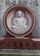 Tokio  Japan  Grabstein mit Buddhafigur auf dem Friedhof am Zojo-ji Tempel