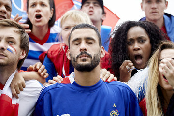 French football fans looking shocked and disappointed at match
