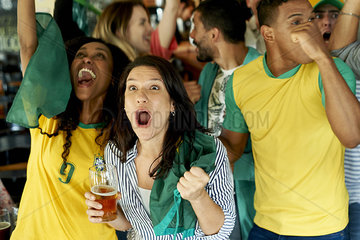Brazilian soccer fans watching match together at pub