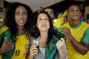 Brazilian football supporters watching match in bar