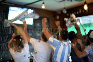Argentinian football fans watching football match at sports bar