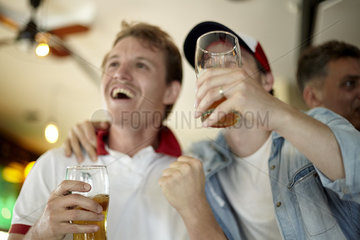 Sports enthusiasts watching match together in bar