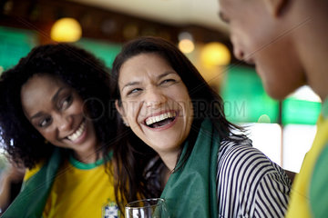 Woman laughing in bar with friends