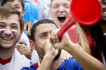 French football supporter playing vuvuzela at match