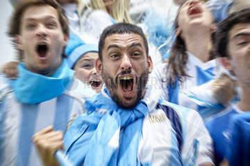 Argentinian football fans cheering excitedly at match