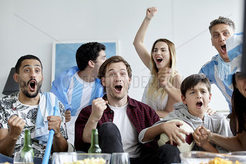 Argentinian football fans cheering while watching match at home