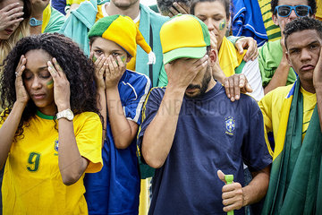 Brazilian football fans looking disappointed at match