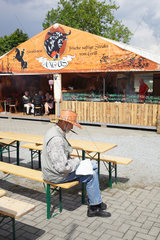 Berlin  Deutschland  Mann mit Cowboyhut sitzt auf einer Bierbank