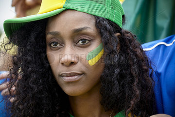 Brazilian football fan wearing hat and face paint  portrait