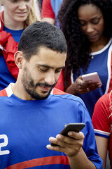 Man looking at smartphone during football match