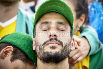 Football fan with head back and eyes closed in disappointment