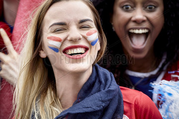 French football fans smiling and cheering at match