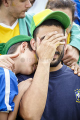Brazilian football fans looking sad after football match