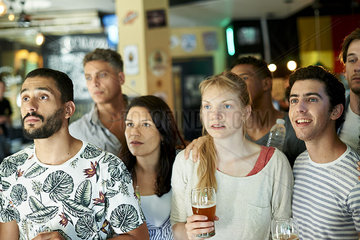 Soccer fans watching match together at pub