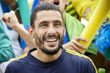 Man smiling cheerfully at football match  portrait