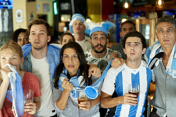 Argentinian soccer fans watching match together at pub