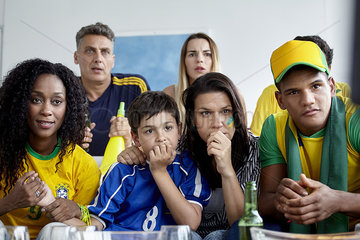 Brazilian football fans watching match together at home