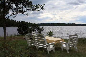 Storsa Lesjoen  Schweden  Gartenstuehle und Tisch an einem See