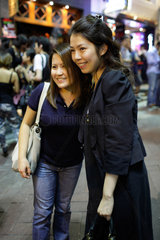 Hongkong  China  Zwei Frauen posieren fuer Fotografen