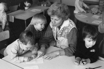Berlin  DDR  Erzieherin in einem Kindergarten zeichnet mit kleinen Kindern