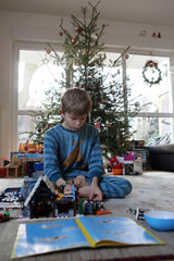 Berlin  Deutschland  Junge spielt an Weihnachten mit seinen neuen Legobausteinen