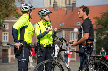 Muenster  Deutschland  Polizisten auf Fahrradstreife kontrollieren einen Fahrradfahrer