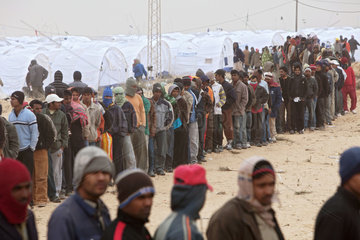 Ben Gardane  Tunesien  Fluechtlinge im Fluechtlingslager Shousha warten auf eine Essensverteilung