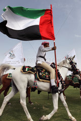 Dubai  Reiter mit Nationalflagge auf einem Arabischen Vollblutpferd