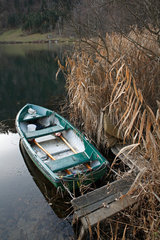 Afritz am See  Oesterreich  verlassenes Ruderboot am Ufer des Sees