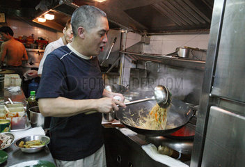 Hong Kong  China  Mann kocht mit einem Wok