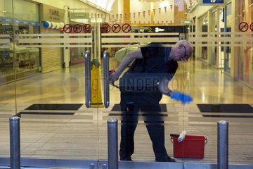 Oxford  Grossbritannien  Fensterputzer reinigt die Eingangstuer einer Einkaufspassage