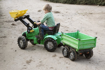 Prangendorf  Junge faehrt mit Spielzeugtraktor