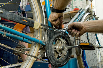 Berlin  Deutschland  Mitarbeiter einer Fahrradreparaturwerkstatt arbeitet an einem Rad