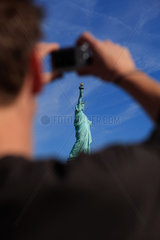 New York City  USA  die Statue of Liberty  durch den Arm eines Touristen fotografiert