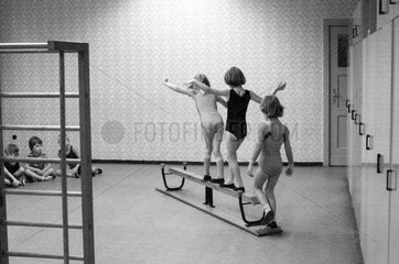 Berlin  DDR  kleine Kinder balancieren im Sportunterricht ueber eine umgedrehte Bank
