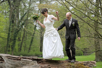 Buckow  Deutschland  Brautpaar balanciert auf einem umgestuerzten Baumstamm