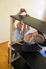 Posen  Polen  zwei Maenner bauen einen Ikea-Schrank auf