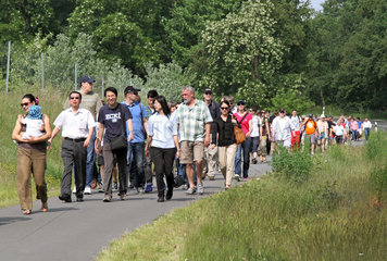 Schoenefeld  Deutschland  Menschen laufen eine Landstrasse entlang