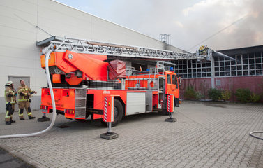 Berlin  Deutschland  Feuerwehrmaenner auf einer Drehleiter bei Loescharbeiten