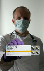 Berlin  Deutschland  ein Arzt mit Mundschutz haelt eine Packung des Medikaments Tamiflu